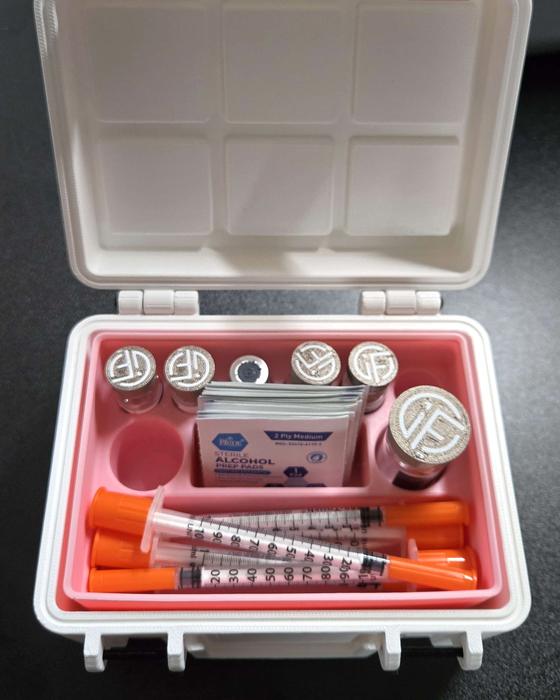 White and pink storage case with vials and supplies